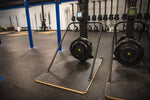 Pictured are two Concept2 Ski Erg's, one with an Adaptive Base By Equip Products, and the other a standard size 24" base in a gym setting on a black floor.